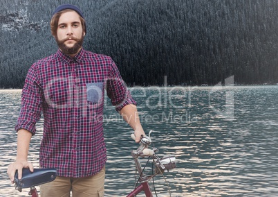 Millennial man with bicycle against river and forest