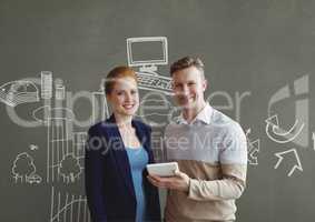 Happy business people holding a tablet against grey background with graphics