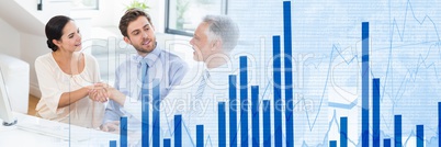 Three businesspeople shaking hands in office wide shot