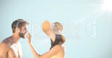 Millennial couple against light blue background with flare