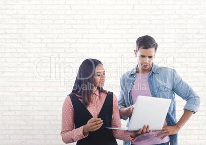 Happy business people using a computer against white wall