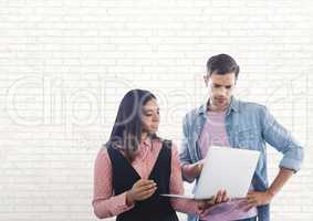 Happy business people using a computer against white wall