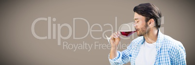 Man tasting wine against brown background