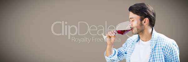 Man tasting wine against brown background