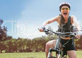 Woman screaming on bicycle against field