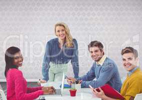 Group of people working at desk in front of grey background
