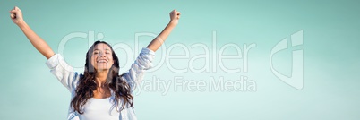 Millennial woman with arms in air against  light green background