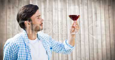 Man tasting wine against blurry wood panel