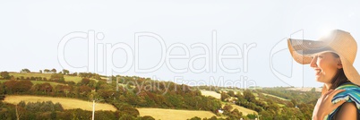 Woman with towel and sun hat against hills