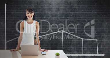 Happy business woman at a desk using a computer against black background with graphic