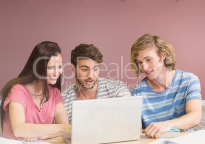 Group of friends with laptop sitting in front of blank rose background