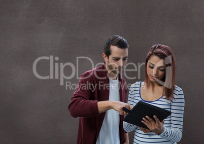 Happy business people using a tablet against brown background