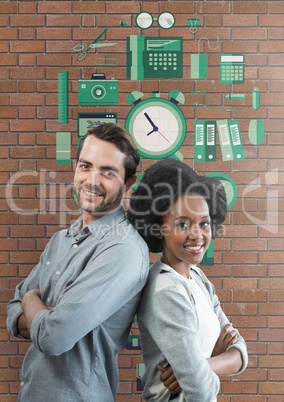 Happy business people standing against brick wall with graphics