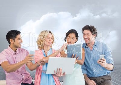 Group of people on devices in front of grey sky background