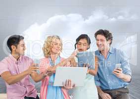 Group of people on devices in front of grey sky background