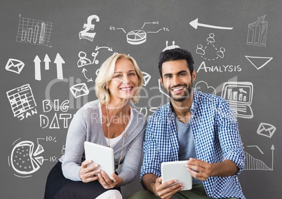 Happy business people holding tablets against grey background with graphics