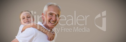 Girl and grandfather piggyback against brown background