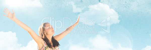 Millennial woman arms in air against Summer sky with flare