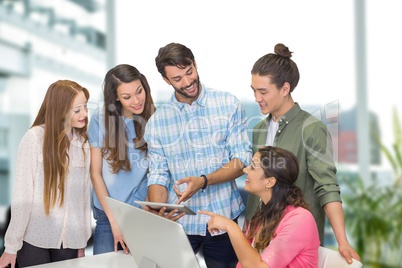 Happy business people at a desk looking at a tablet