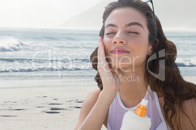 Woman at the beach putting on cream