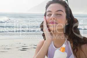 Woman at the beach putting on cream