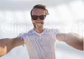 man taking casual selfie photo in front of blurred bright background