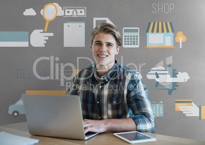 Happy business man at a desk using a computer against grey background with graphics