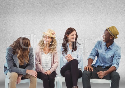 Group of people sitting in front of grey background