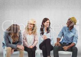 Group of people sitting in front of grey background