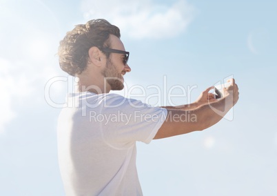 man taking casual selfie photo in front of sky