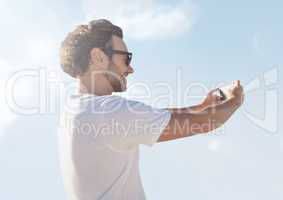 man taking casual selfie photo in front of sky