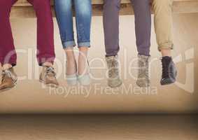Group of people's legs sitting on wooden plank in front of brown background