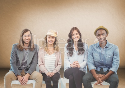 Group of people sitting in front of brown background