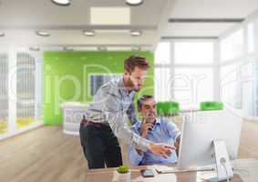 Business men at a desk pointing at a computer