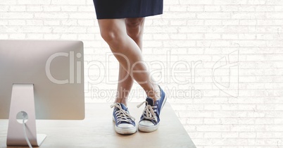 Business woman on a desk against white wall