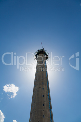 sun behind tall tower