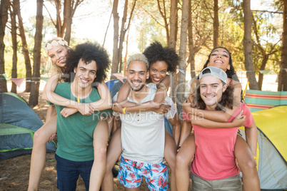 Portrait of men piggybacking female friends