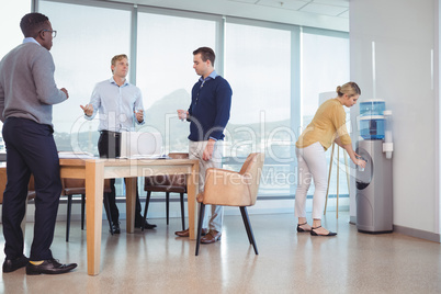 Business colleagues holding drinking glasses at office cafeteria
