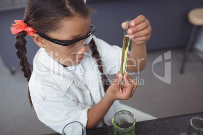 High angle viewof elementary student examining yellow chemical in test tube