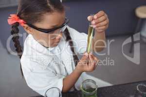 High angle viewof elementary student examining yellow chemical in test tube
