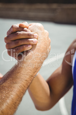 Cropped image of male basketball players holding hands