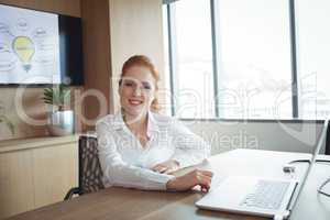 Portrait of smiling businesswoman sitting at office