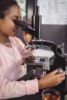 Elementary student using microscope at laboratory