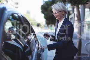 Businesswoman opening car door