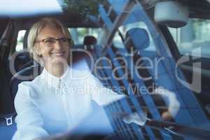 Smiling businesswoman driving car