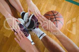 Friends exercising while sitting on hardwood floor in court