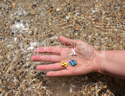 Female hand holds wooden multicolored letters