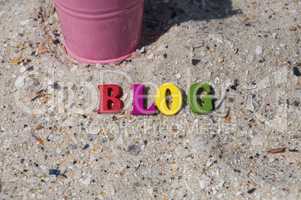 Multicolored wooden letters on the sand