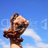 Man's hand is chained in iron chains