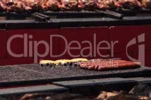 Sausage on a barbecue to cook at a fair ground.